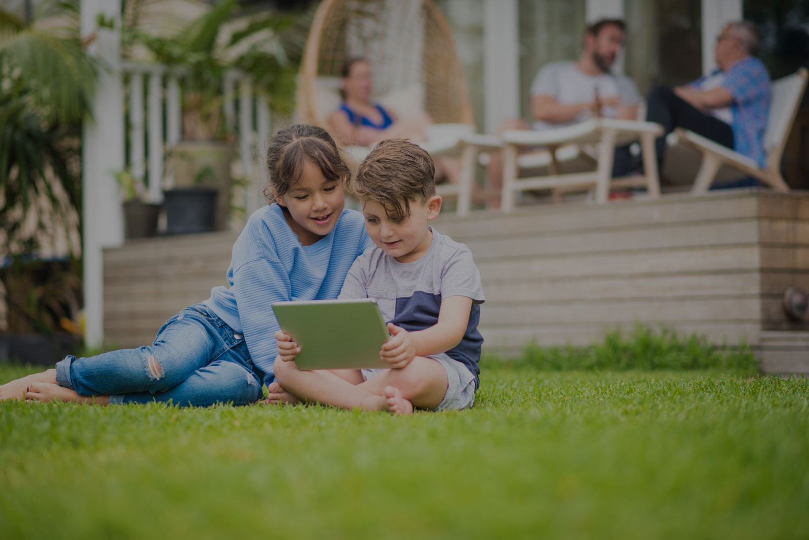 two children looking at a tablet tint